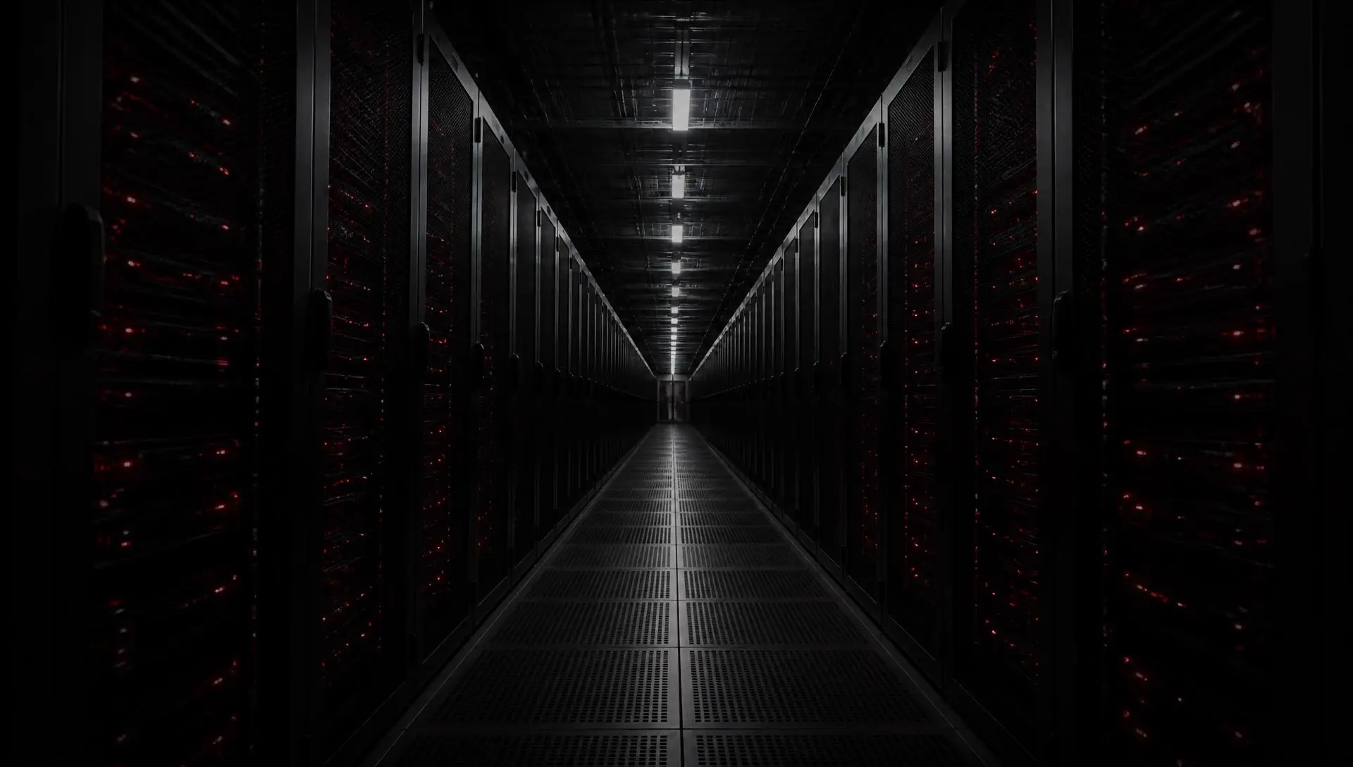 A dark data centre aisle lined with server racks and indicator lights