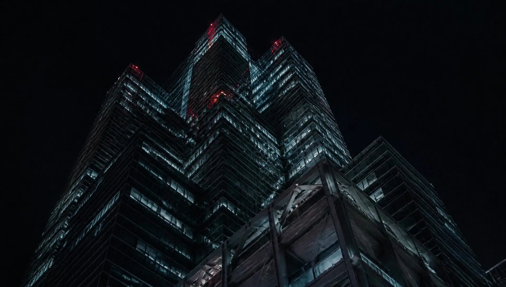 A Hong Kong Central skyscraper facade seen from street level at night